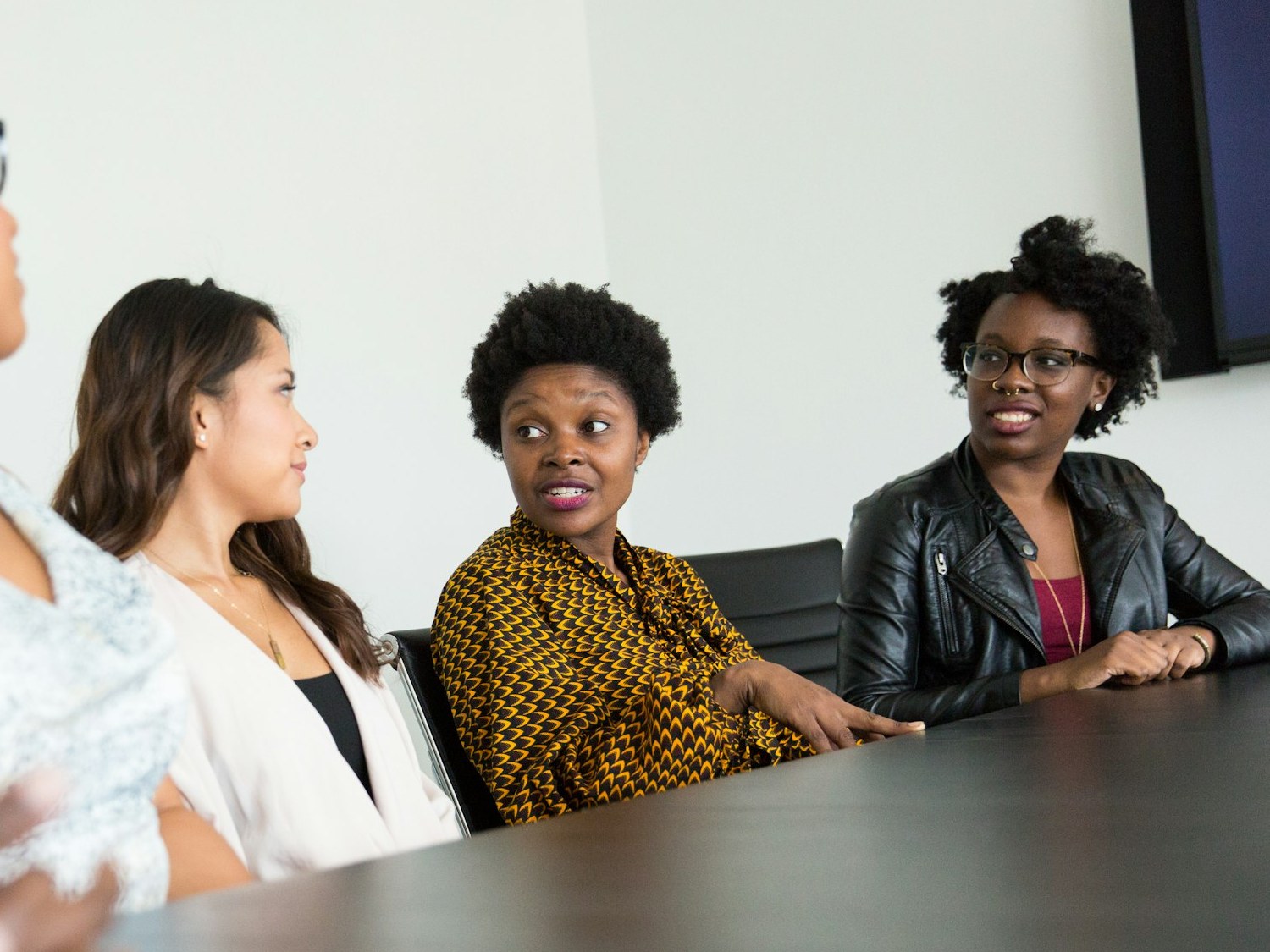 Three colleagues in discussion around a meeting table