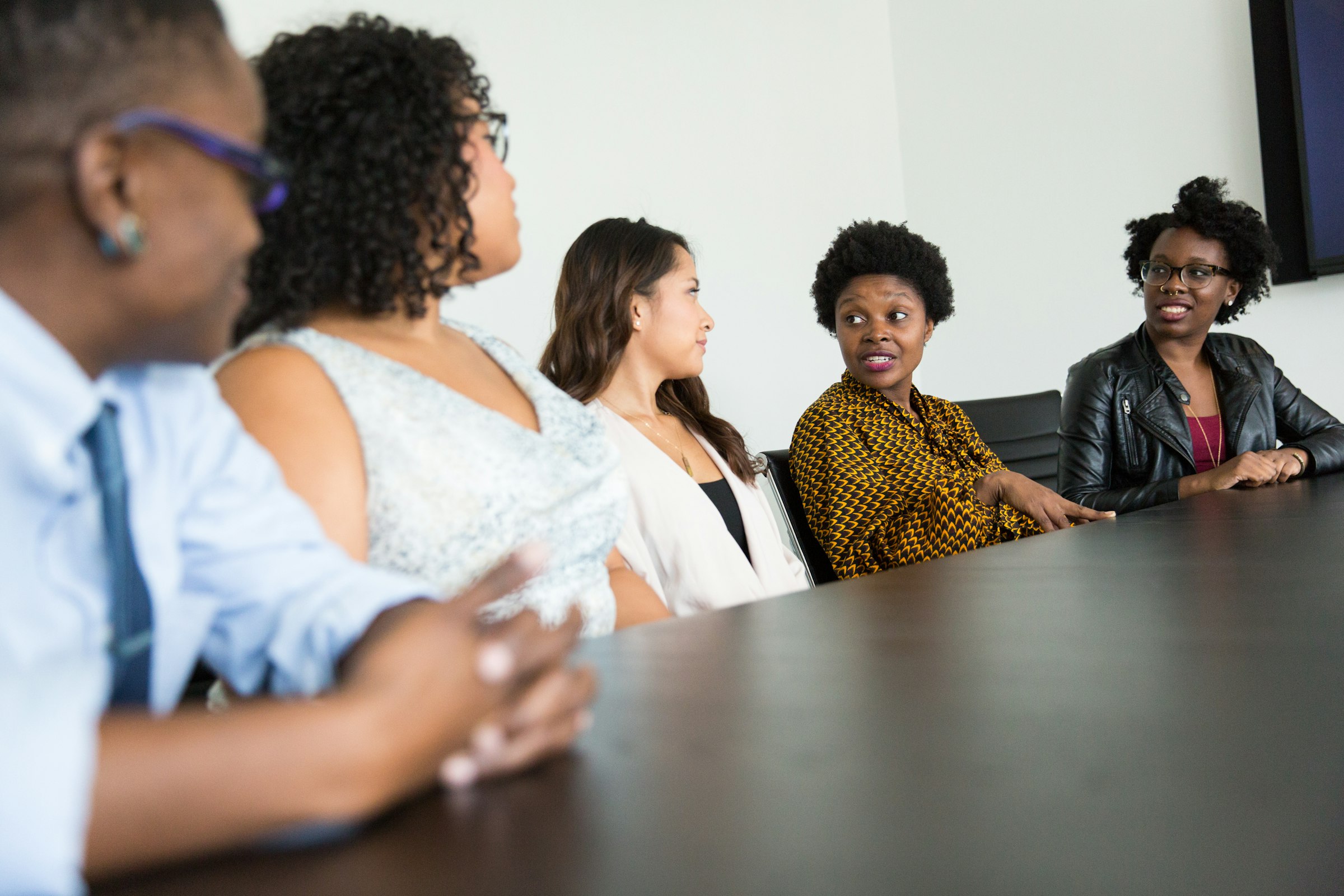 A team of colleagues in conversation around a conference table