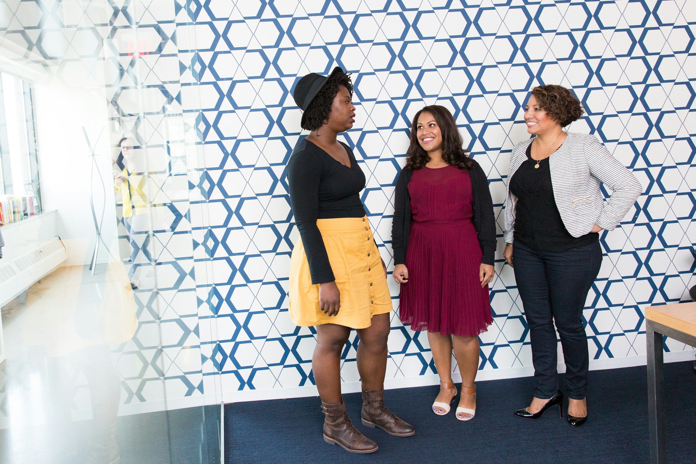 Colleagues talking together in a modern office hallway